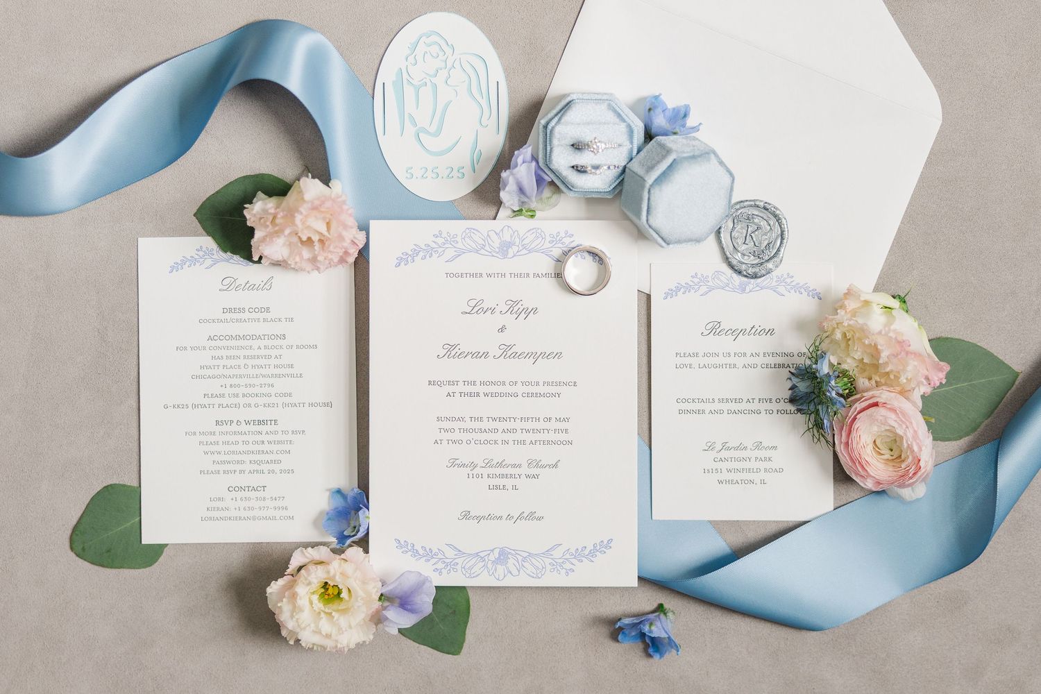 Elegant wedding invitation suite with blue ribbon, pink roses, and wax seal on beige background.
