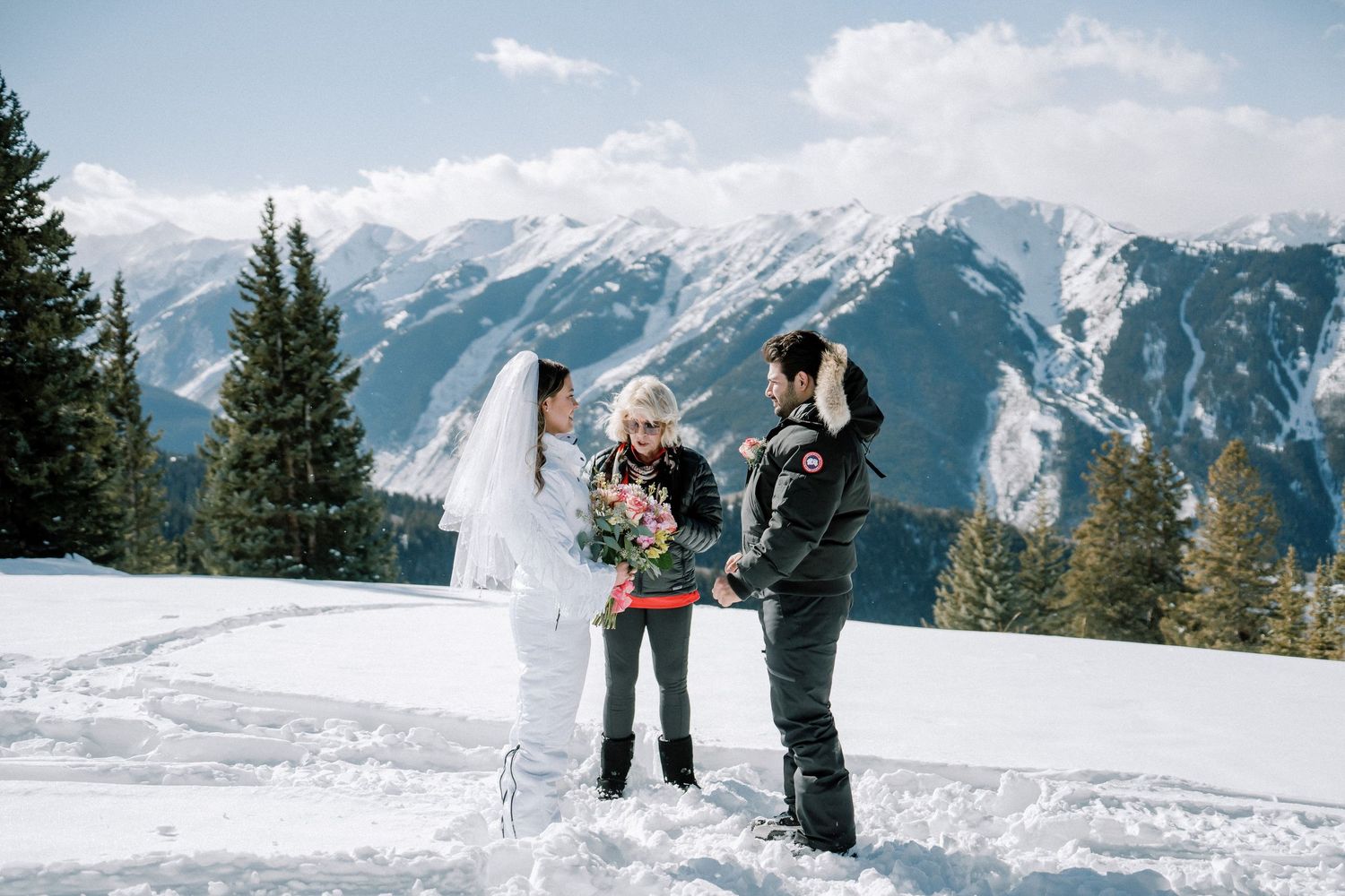 Natalie and Christian are exchanging vows on a snowy mountaintop, surrounded by breathtaking views and the quiet beauty of nature, marking t