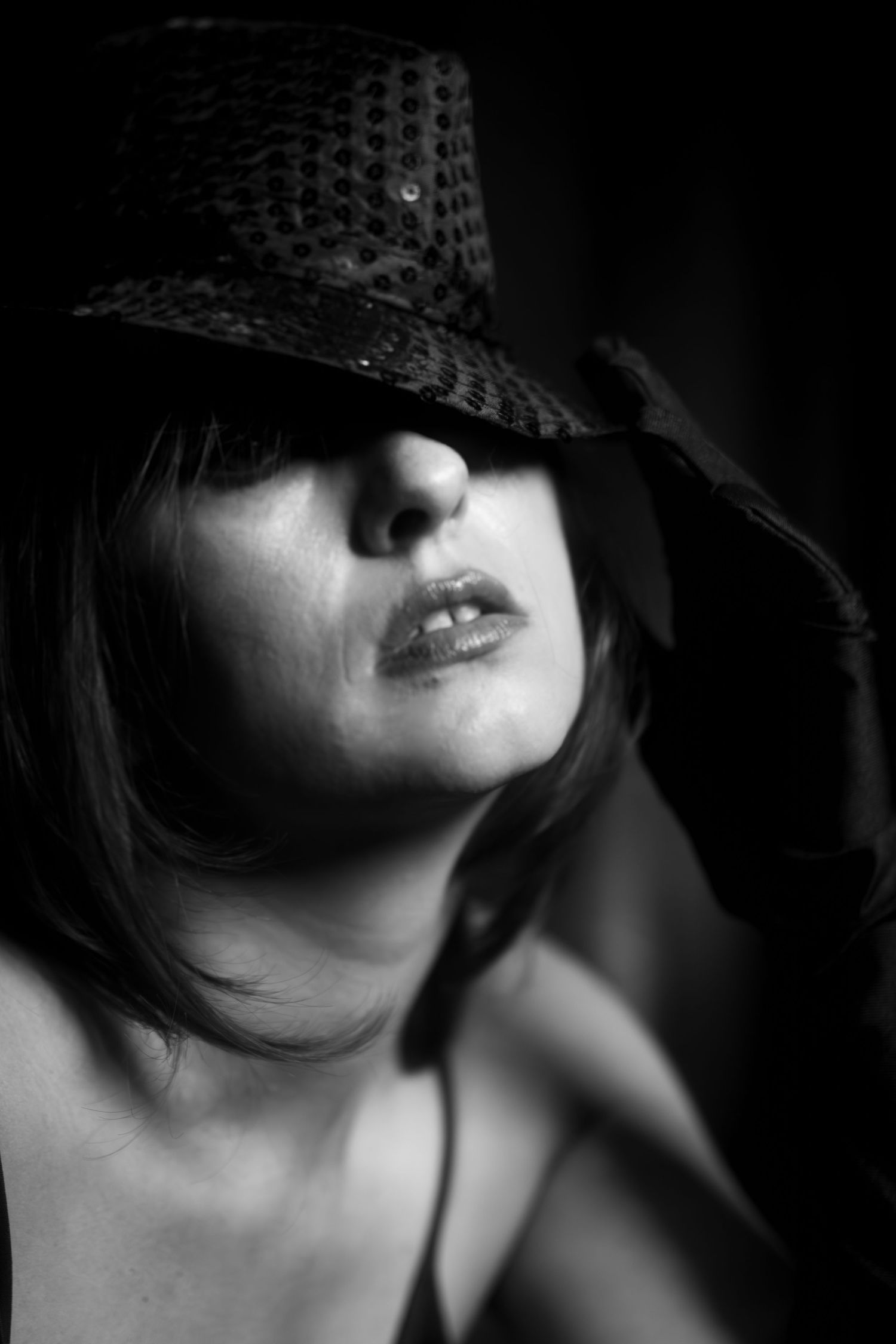 Fort Worth boudoir photo with dramatic lighting and sequin hat, reclaiming artistic identity and inner child joy.
