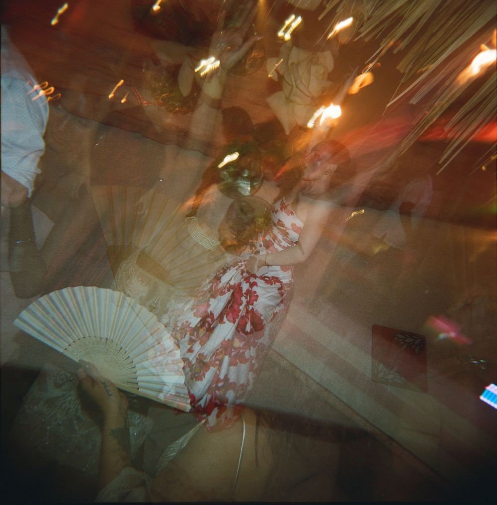 Blurry artistic photo showing a decorative hand fan with glowing lights and atmospheric effects in dark setting.