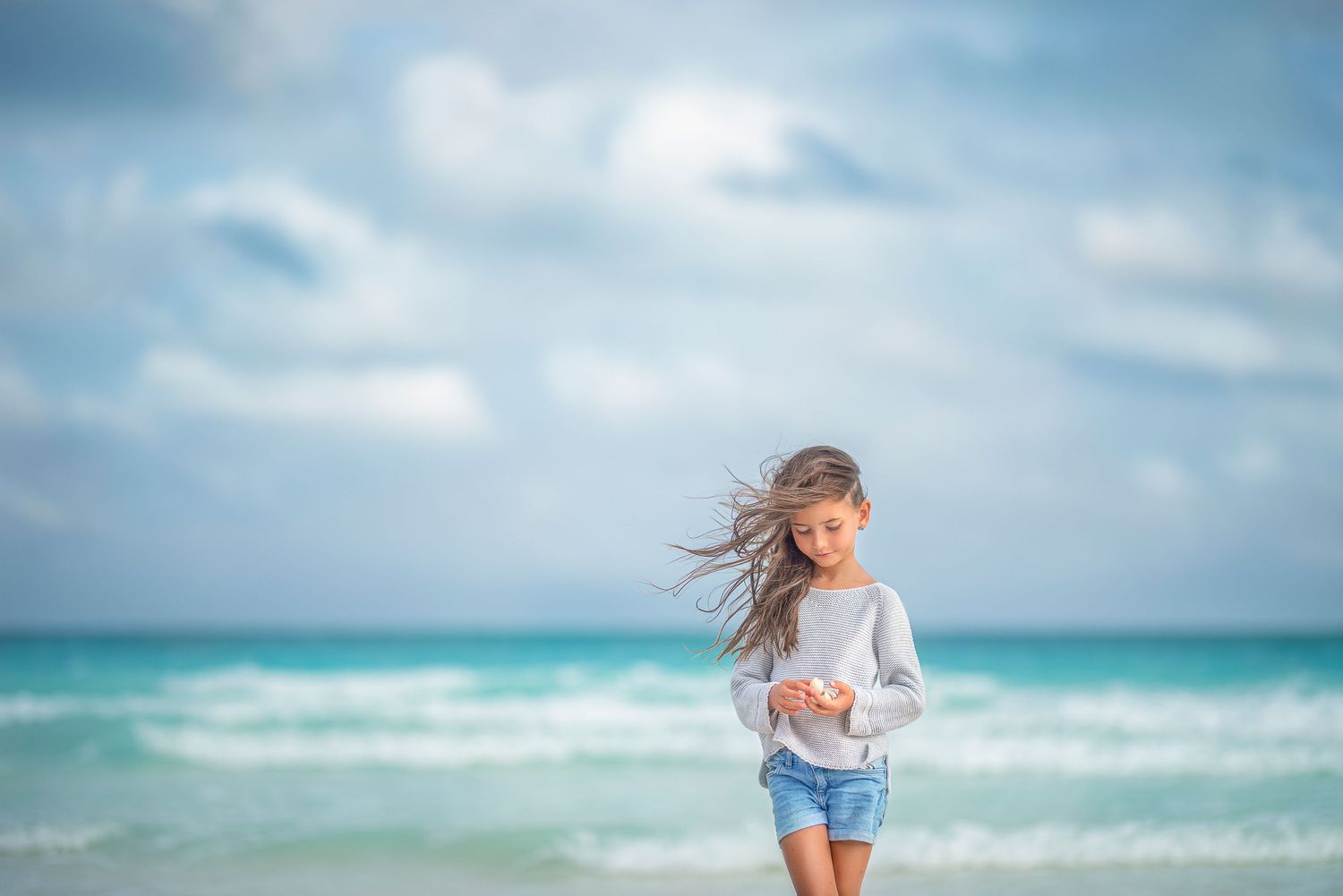 Portrait of the girl by the ocean in cloudy day in Melbourne Beach, florida.