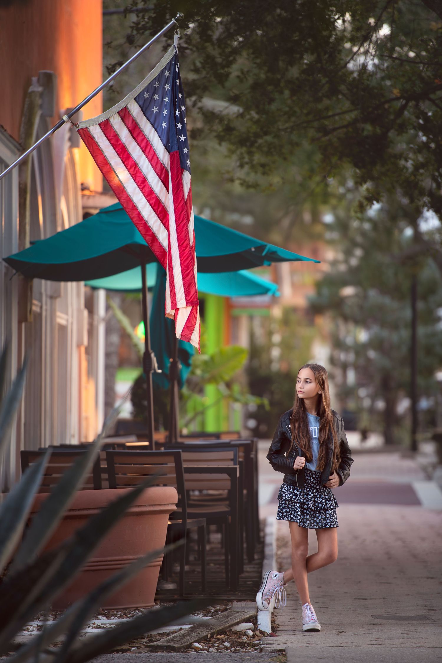 Portrait of the girl in downtown Cocoa Beach on the street beside American Flag.
