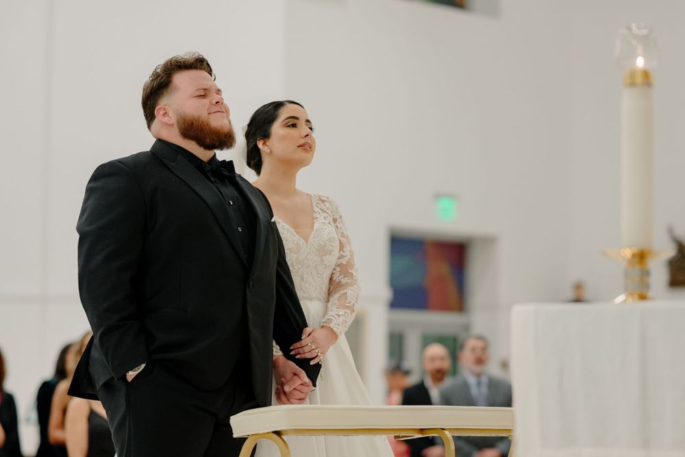 A bride and groom stand together at the altar during their traditional church wedding ceremony.