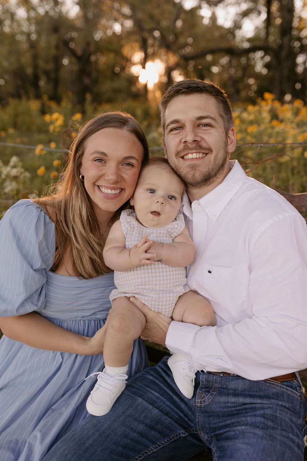 Outdoor family portrait at sunset with golden wildflowers in background.