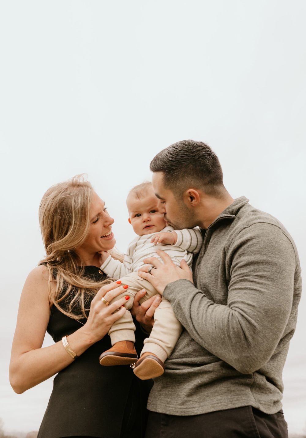 A happy family sharing a playful moment together against a bright background.