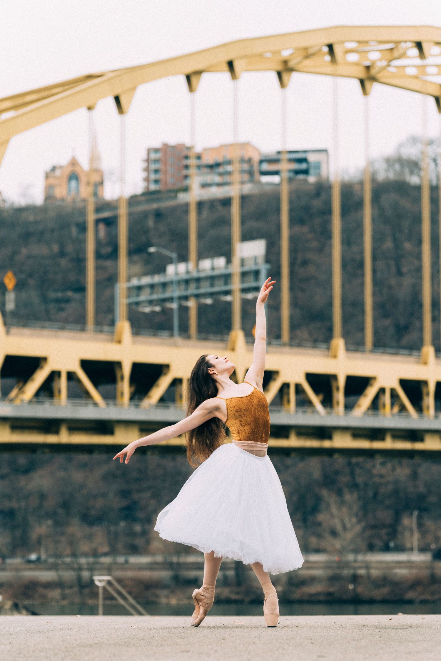 Ballerina in romantic tutu posed on Pittsburgh rooftop at golden hour. Pittsburgh dance photography for ballet