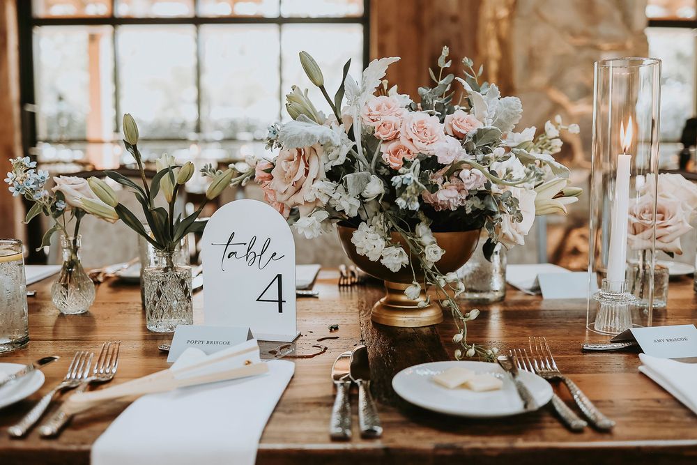 Head table with greenery runner, cream taper candles, and powder blue accents