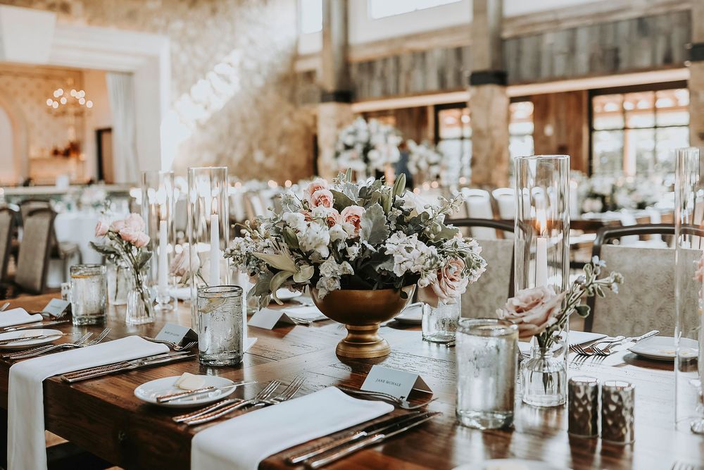 Romantic place settings with ivory linen, blush floral sprig, and personalized menu