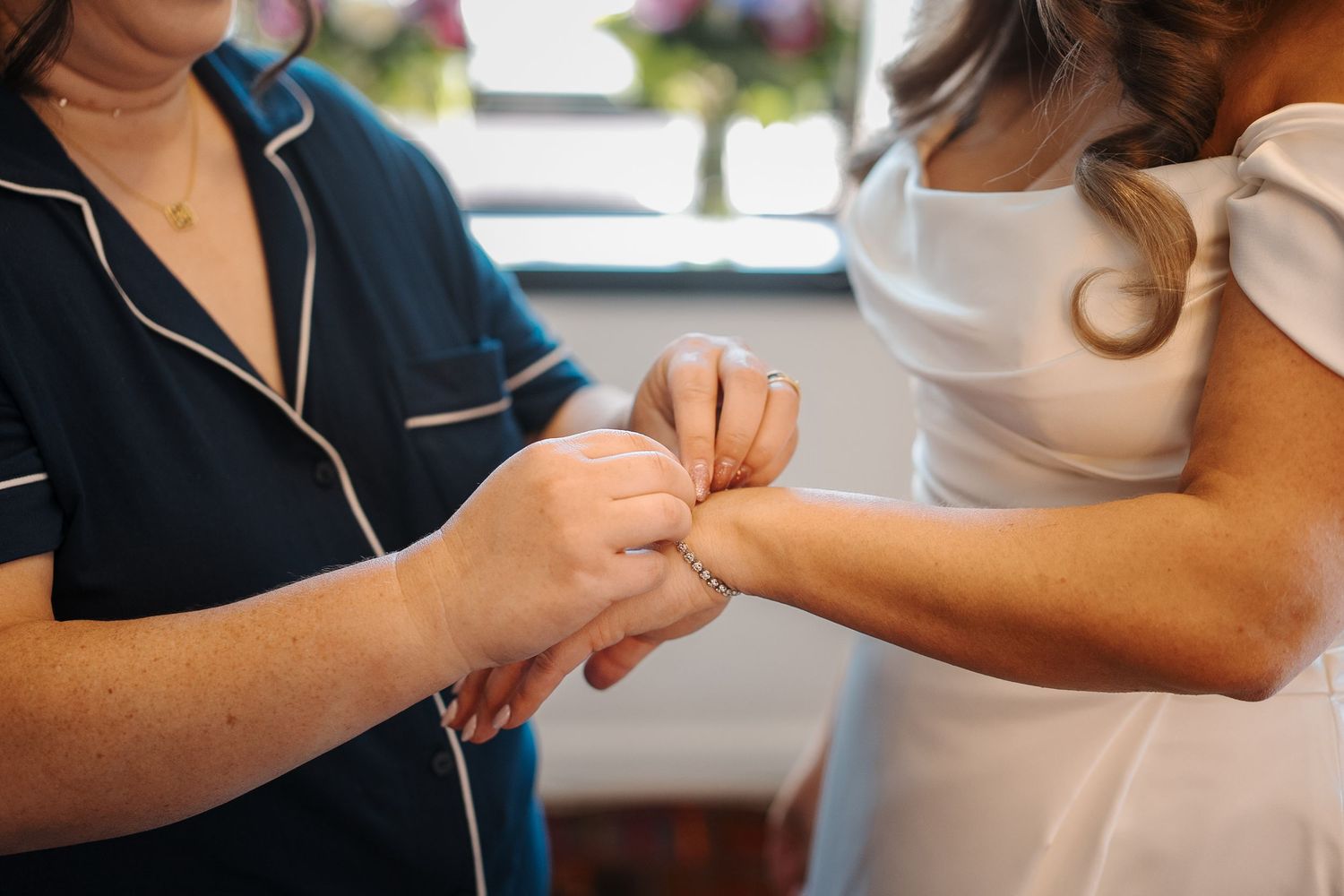 Healthcare professional providing gentle pulse check on patient's wrist during medical examination.