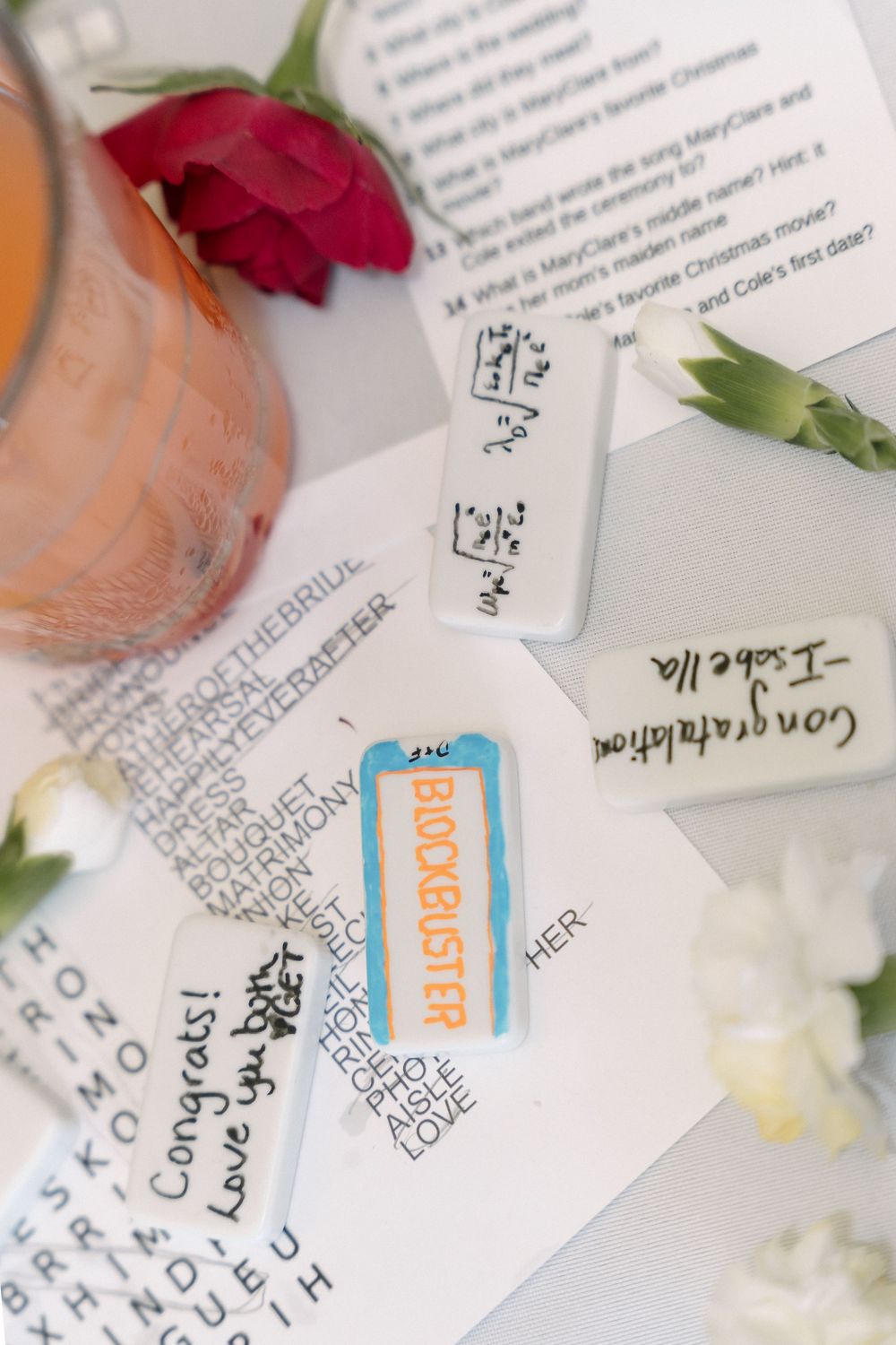 Close-up view of handwritten notes with red rose petals and a blue ticket visible.