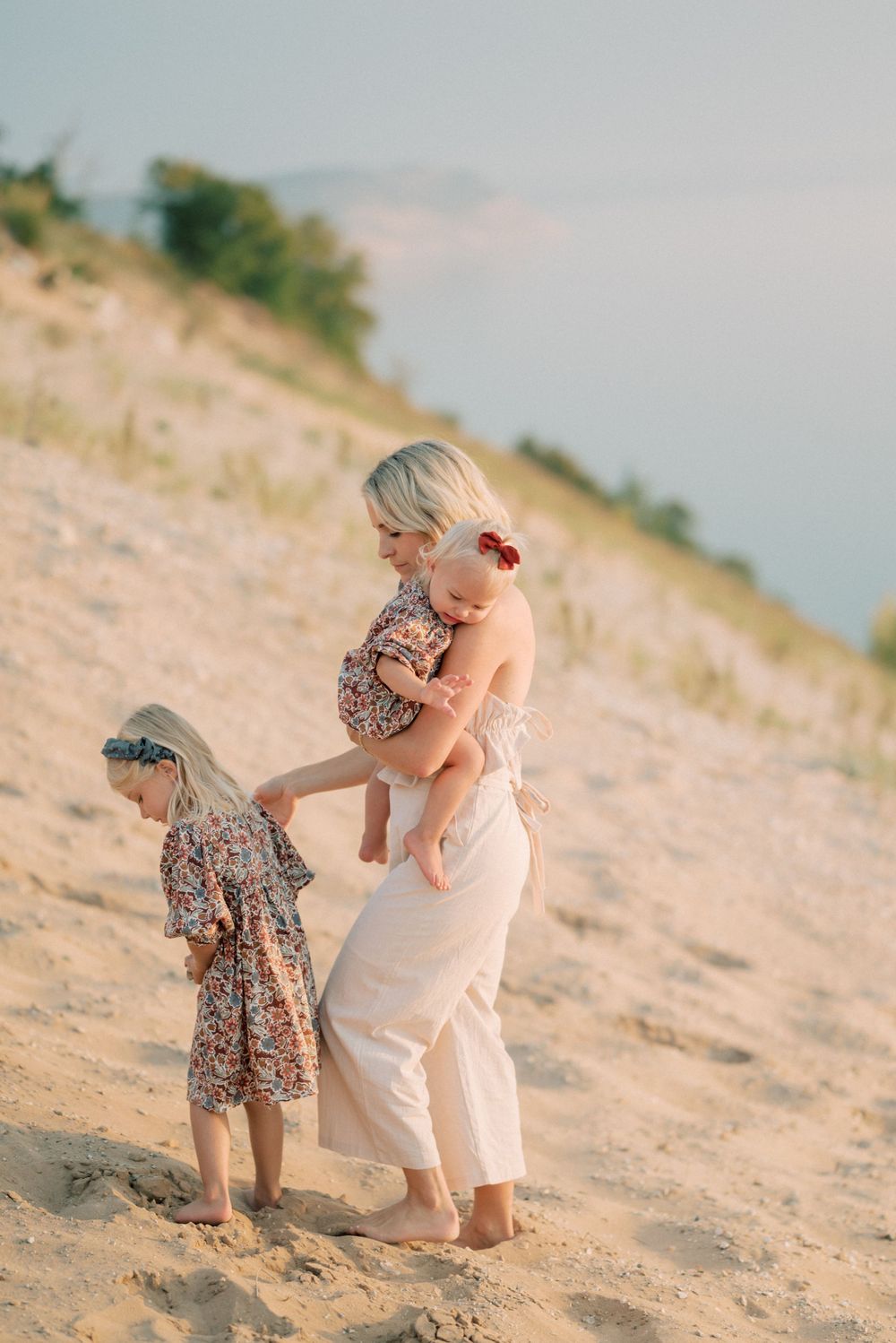 Family enjoys time together on scenic sand dunes during sunset.