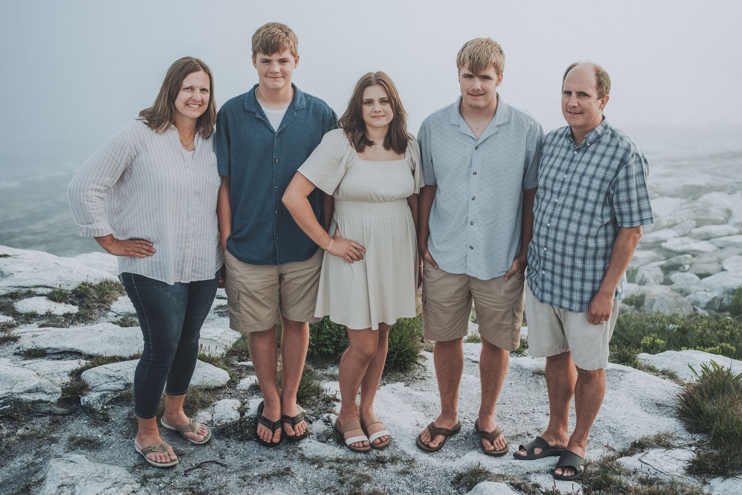 A family of five stands atop a group of rocks at Reid State Park in Georgetown, Maine.