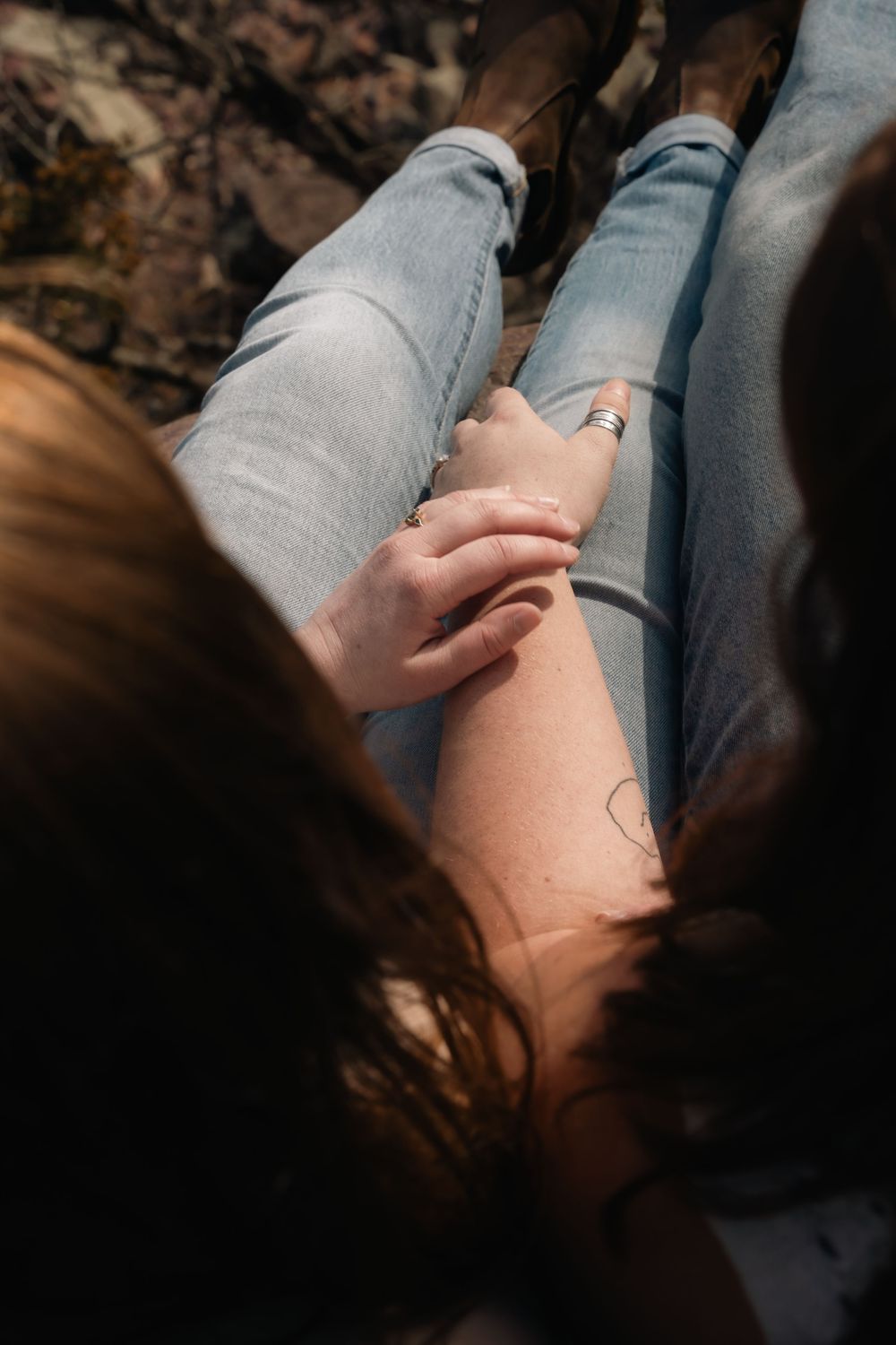 A person rests wearing grey sweatpants with a small minimalist tattoo visible on their thigh.