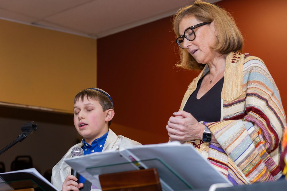 Two people reading from documents at a podium during a ceremony.