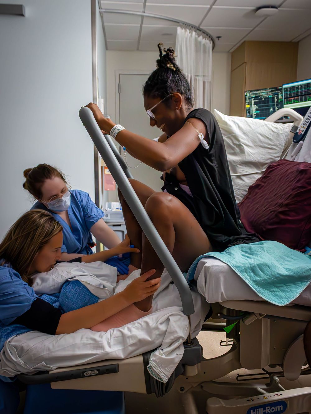 A new mom pushes during labor and delivery with healthcare workers assisting her.