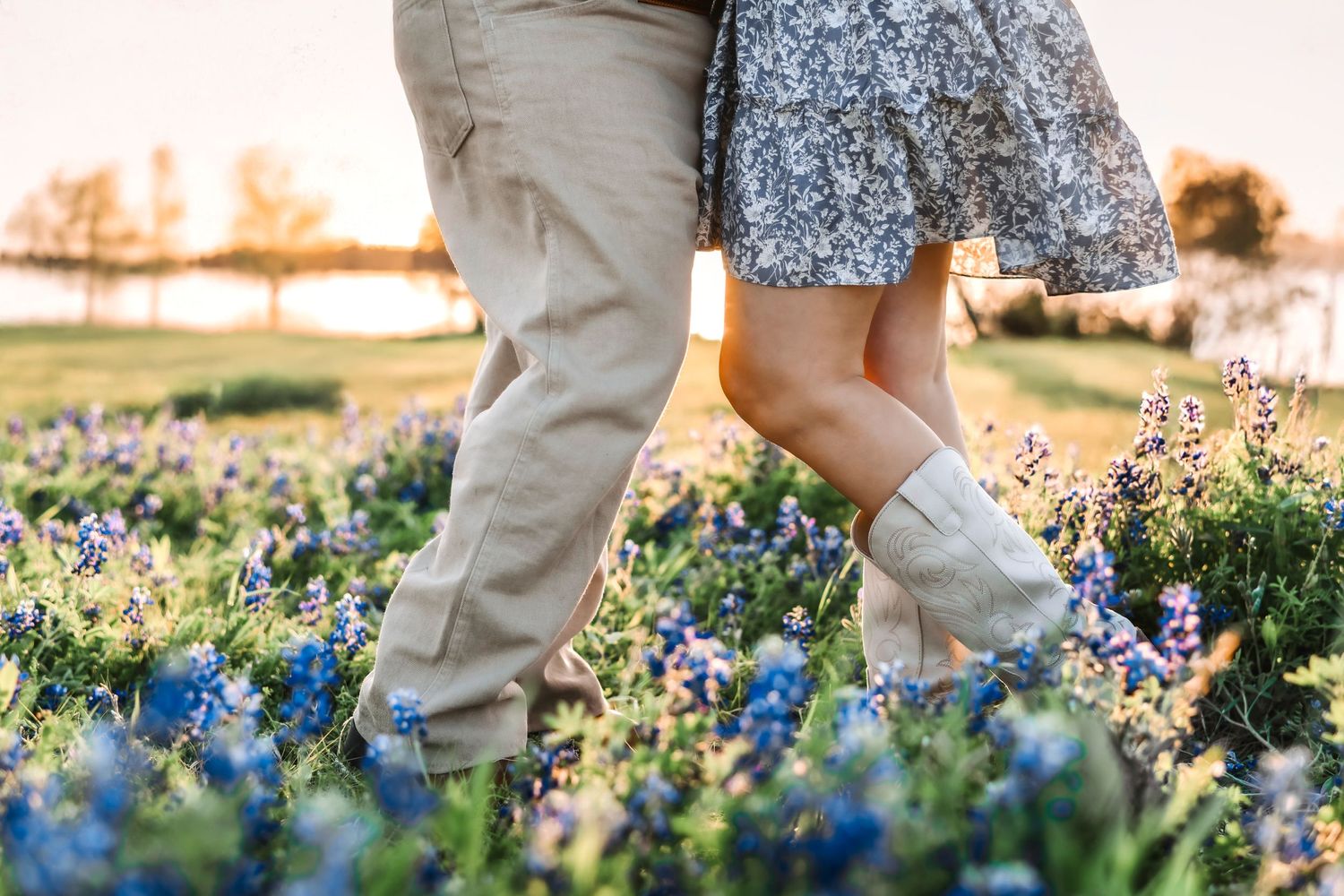 Candid photo of engaged couple lounging in the bluebonnets, smiling at each other in the soft spring sunlight