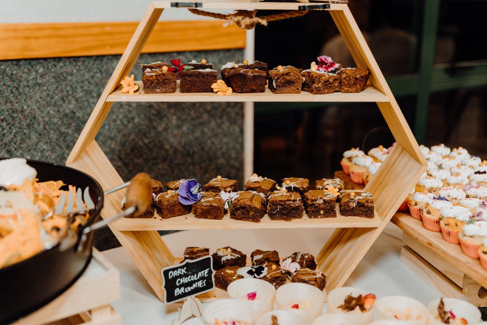 Geometric wooden display shelf showcasing an array of wedding desserts and treats.