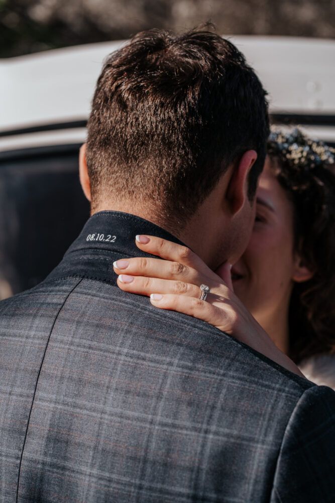Newly married groom in a plaid suit jacket with a personalised wedding date on inside of jacket collar.