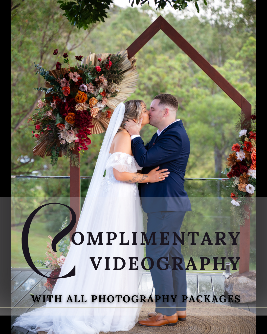 Wedding ceremony setup with wooden arch decorated with red and pink florals in garden setting.
