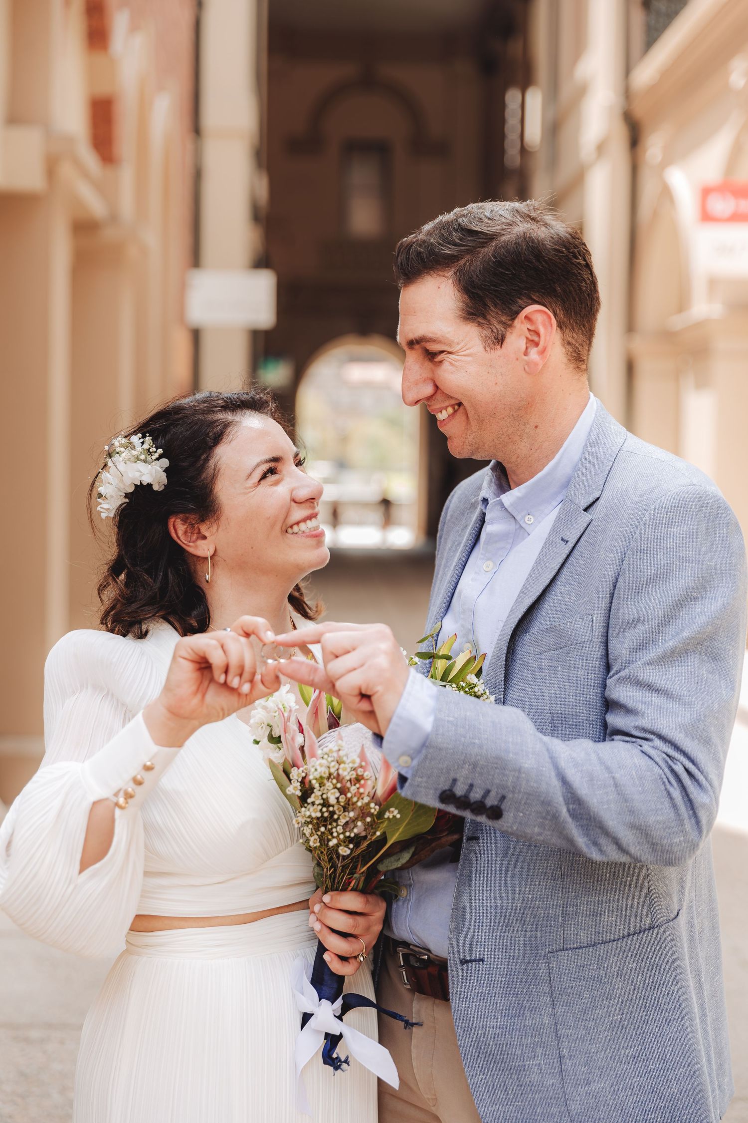 A reception toast moment captured at a beautiful bayside wedding venue surrounded by glass windows and natural light.