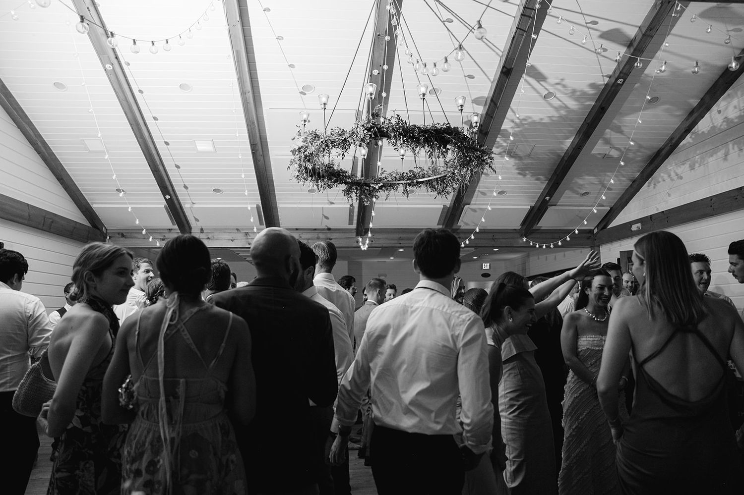 Large crowd gathers inside a tent structure during a festive or social event creating a lively atmosphere.