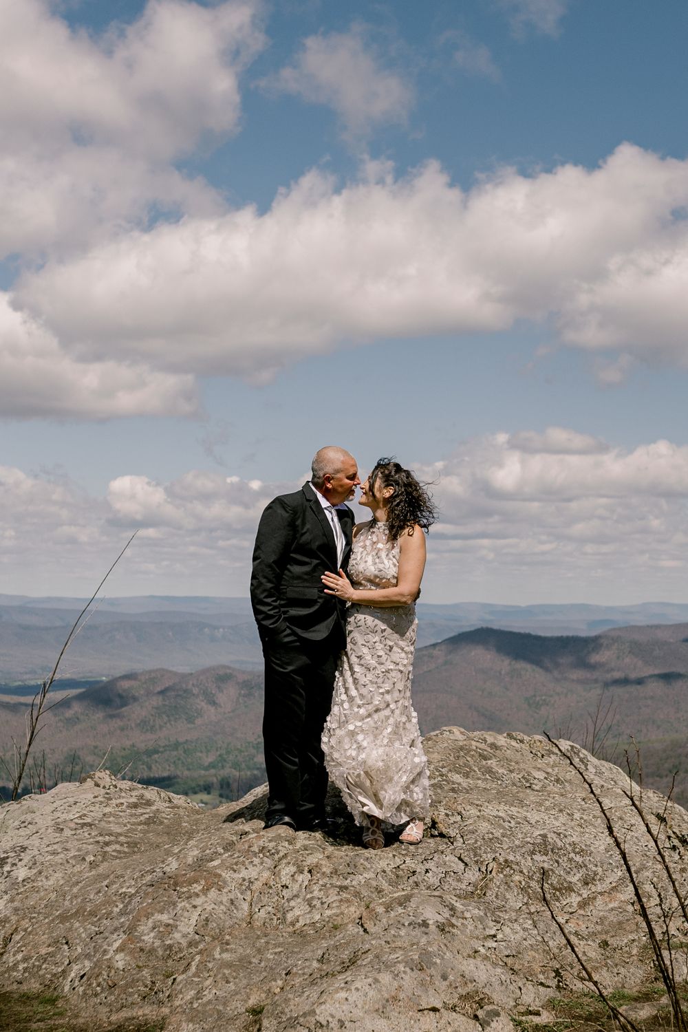 Newlyweds sharing an intimate moment on Shenandoah National Park overlook with sweeping valley views.