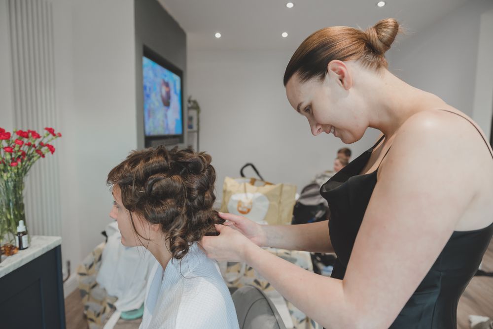 Preparation scene of wedding day hair styling in bright room.