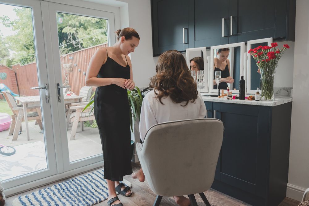 Hair styling session in modern salon with large windows and dark cabinets.