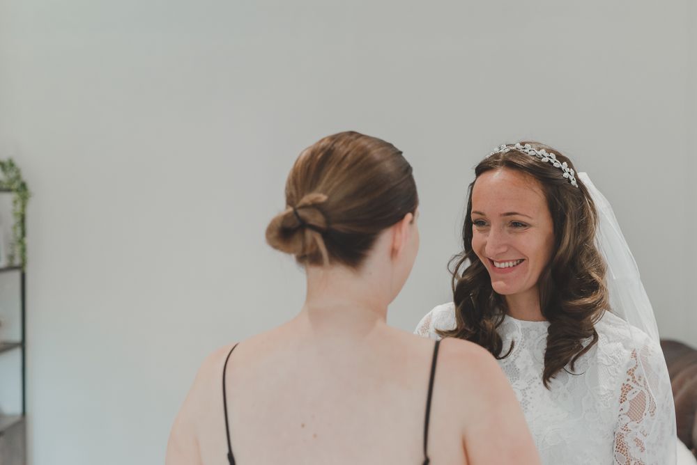 Wedding preparation moment captured in natural light with elegant white details.