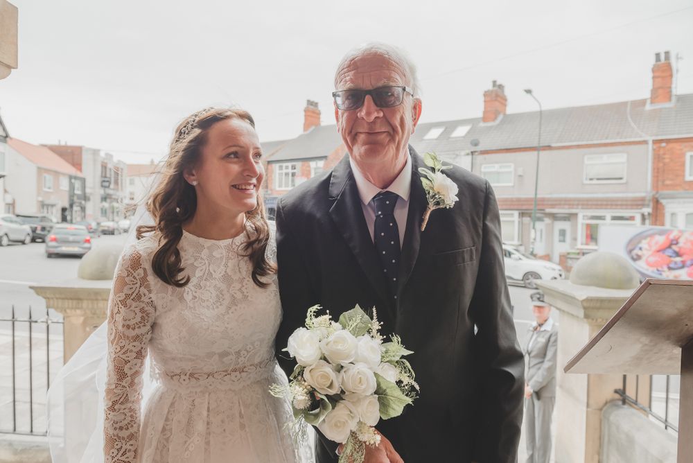 A wedding couple shares a joyful moment outdoors on stone steps.
