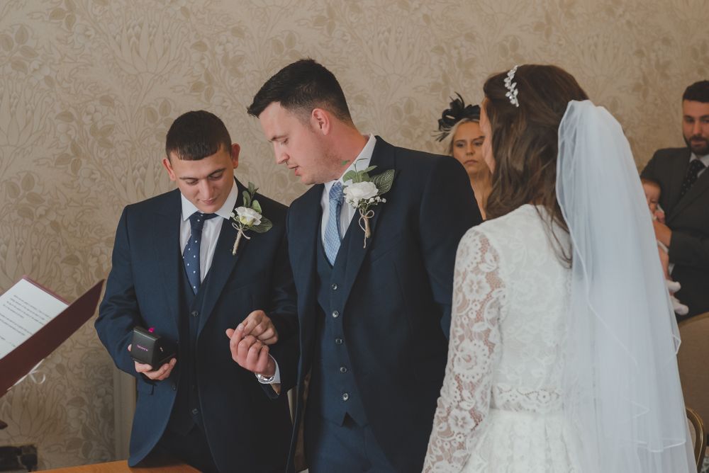 Couple exchanges vows during an intimate wedding ceremony with officiant and guests in attendance.