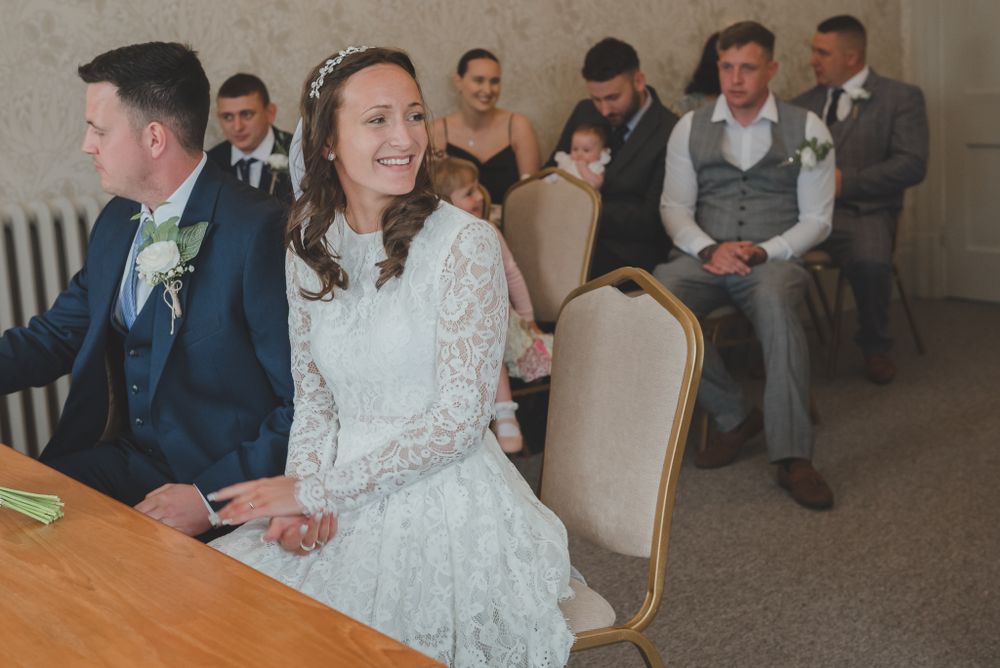 Wedding celebration in progress with seated guests watching ceremony proceedings.