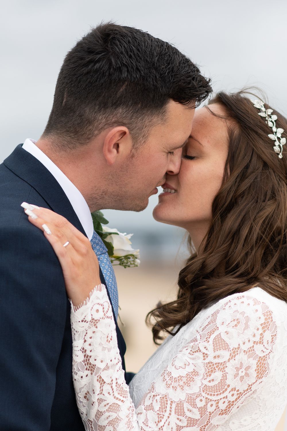 Close-up of romantic couple kissing in wedding attire.