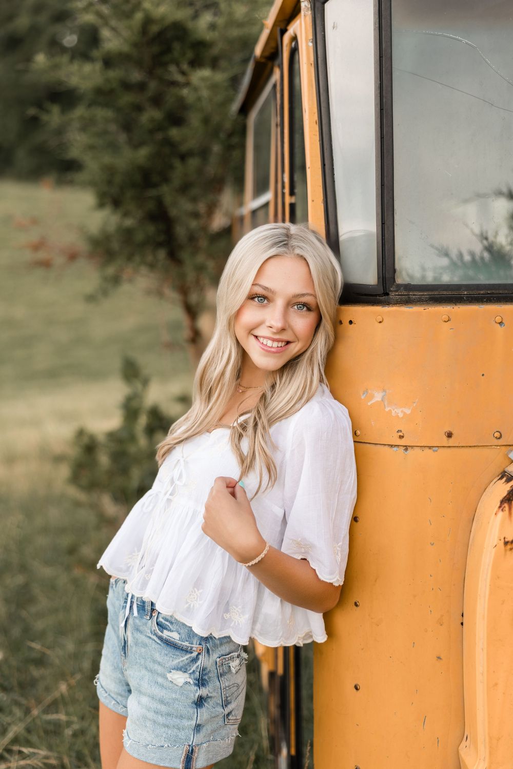 Casual outdoor portrait series showing playful poses against a vintage yellow school bus.