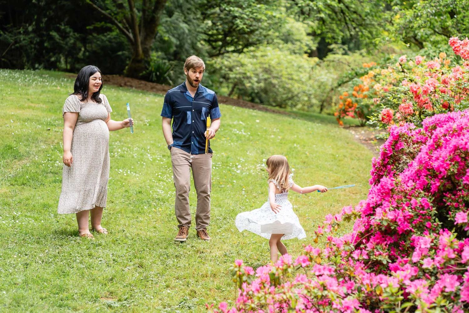 Daughter twirling and playing with bubbles while parents look on.