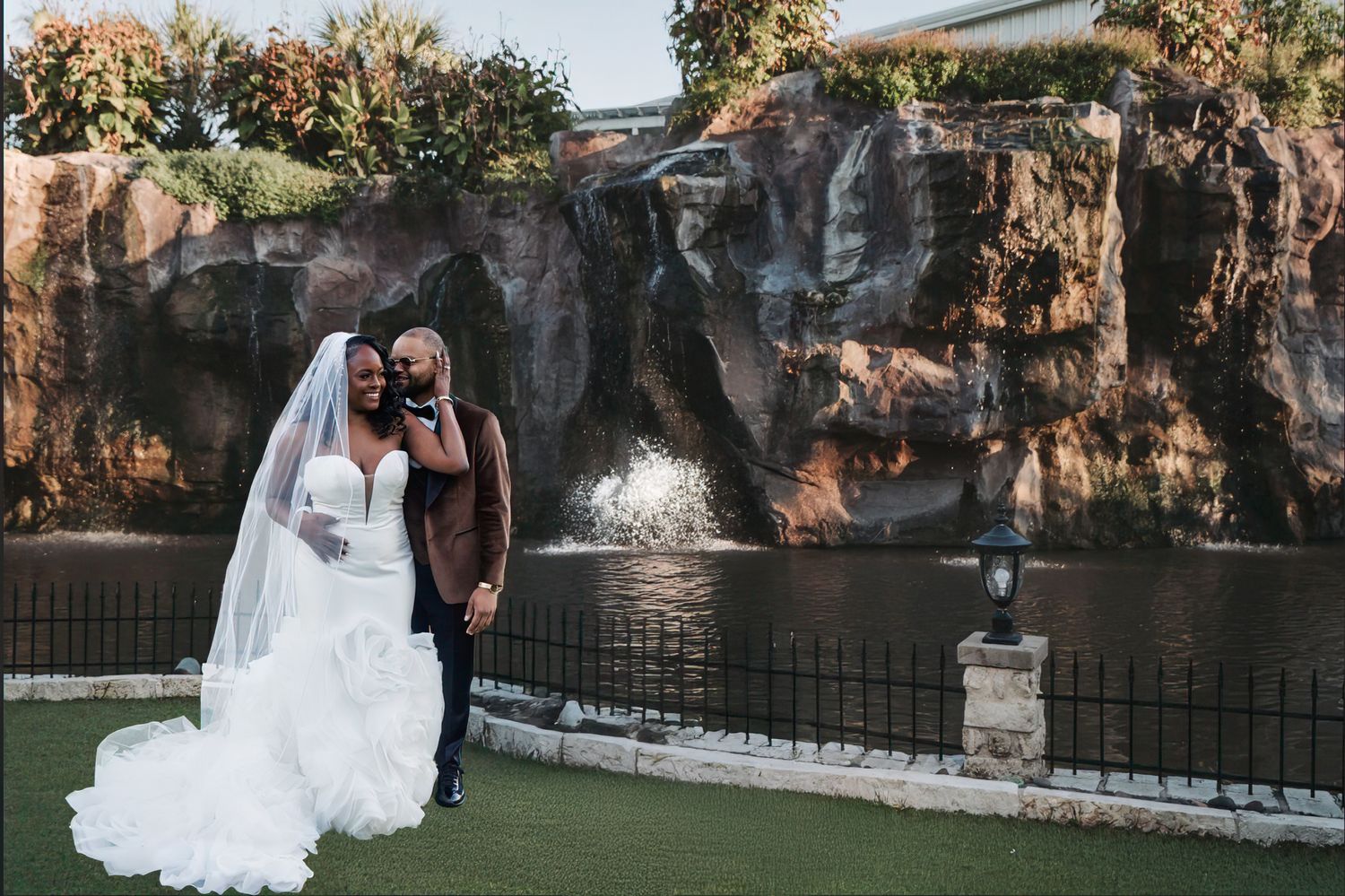 Couple poses by a water feature at the Dallas Oasis, a Dallas wedding venue