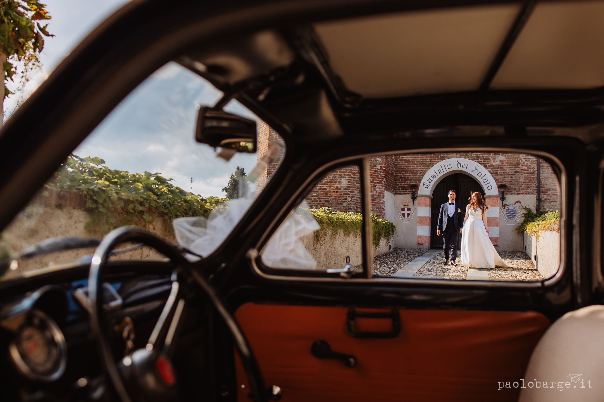 Interior view of a vintage car showing distinct brown leather seats and dashboard details through multiple window perspectives.