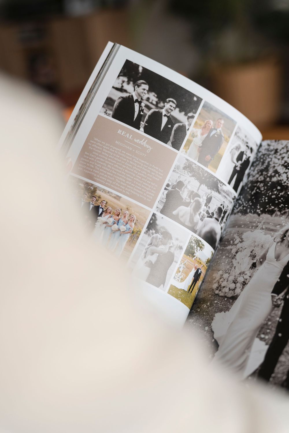 Close-up view of opened wedding photo album pages with black and white photographs displayed in a soft focus layout.