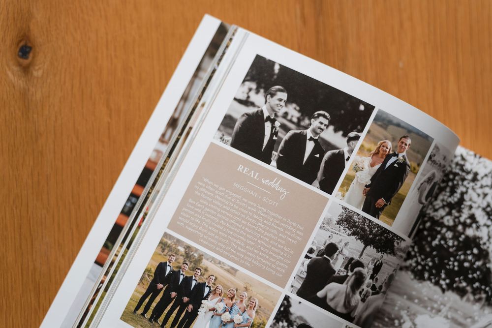 A wedding photo album page spread showing multiple black and white photographs on a wooden background surface.
