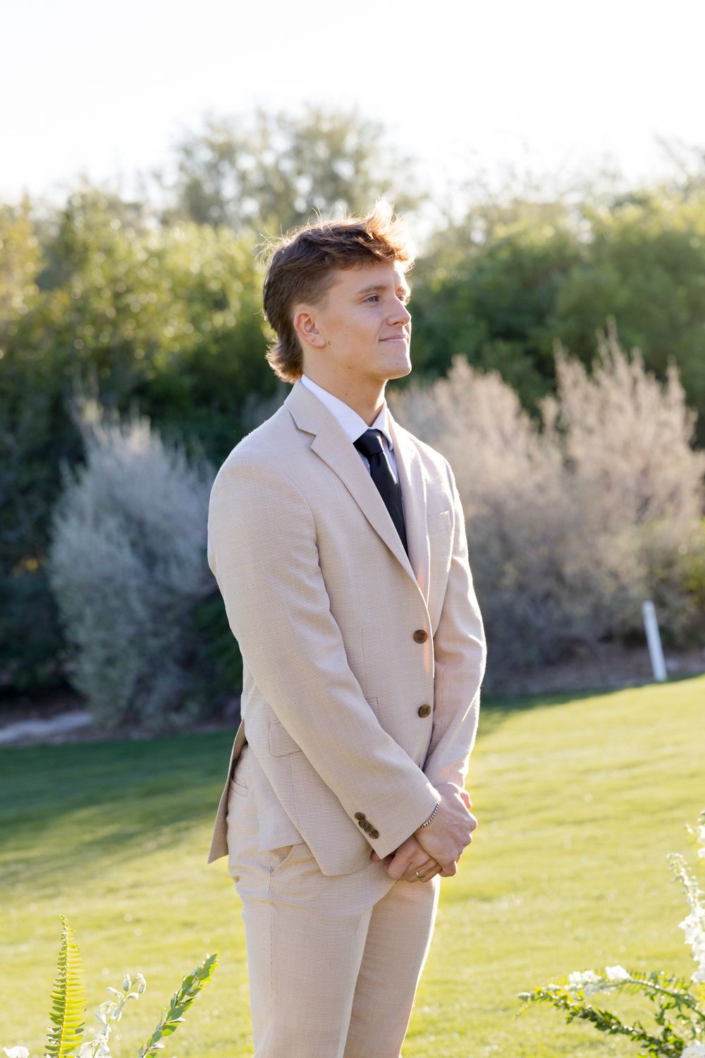 Formal attire being worn on a scenic golf course with desert landscape in background.