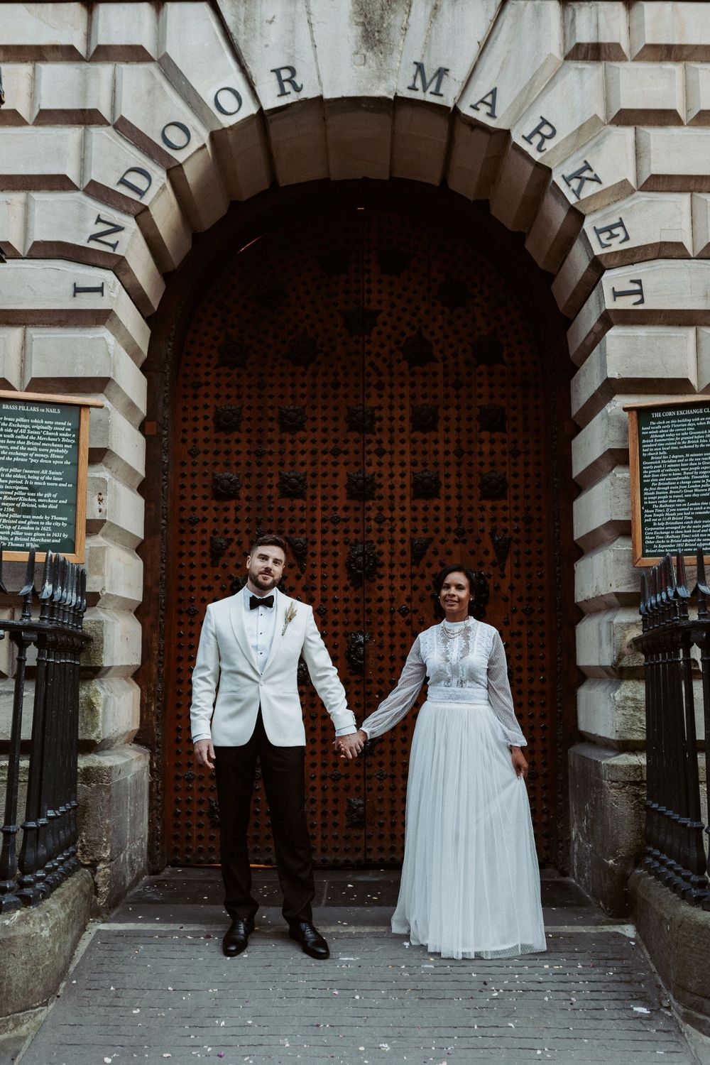 A bride and groom pose in sequence against an ornate stone doorway showing their movement in a creative wedding photo series.