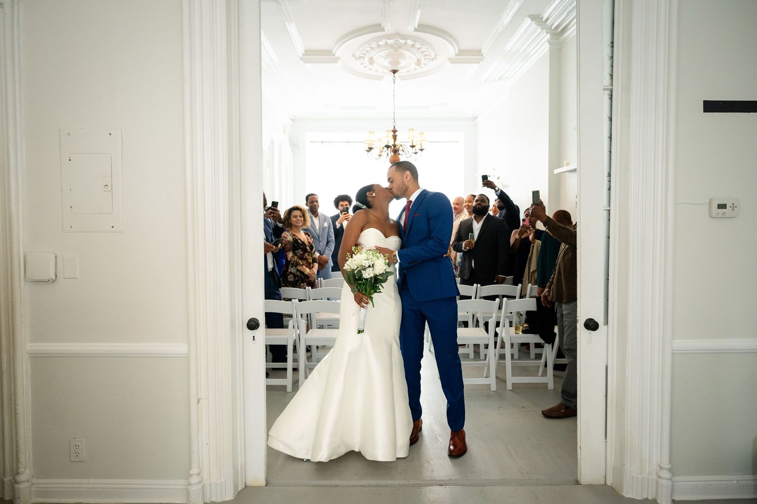 White minimalist wedding venue with tall ceilings and classic crown molding details.