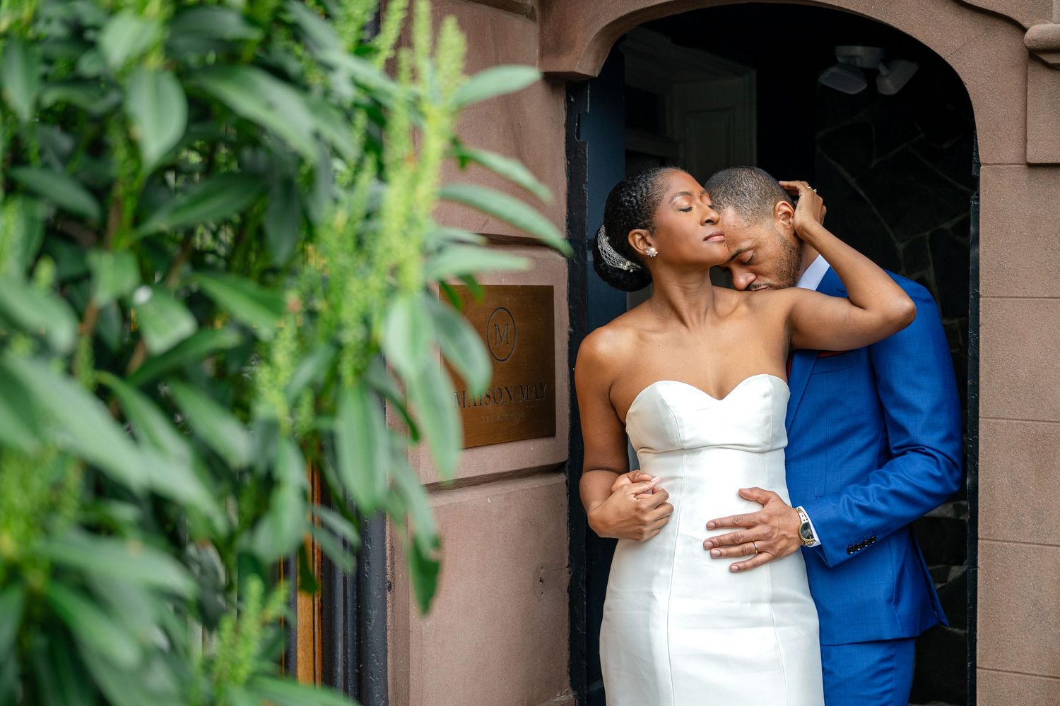 Joyful couple embraces and shares intimate moments while taking outdoor wedding photos in a lush garden.