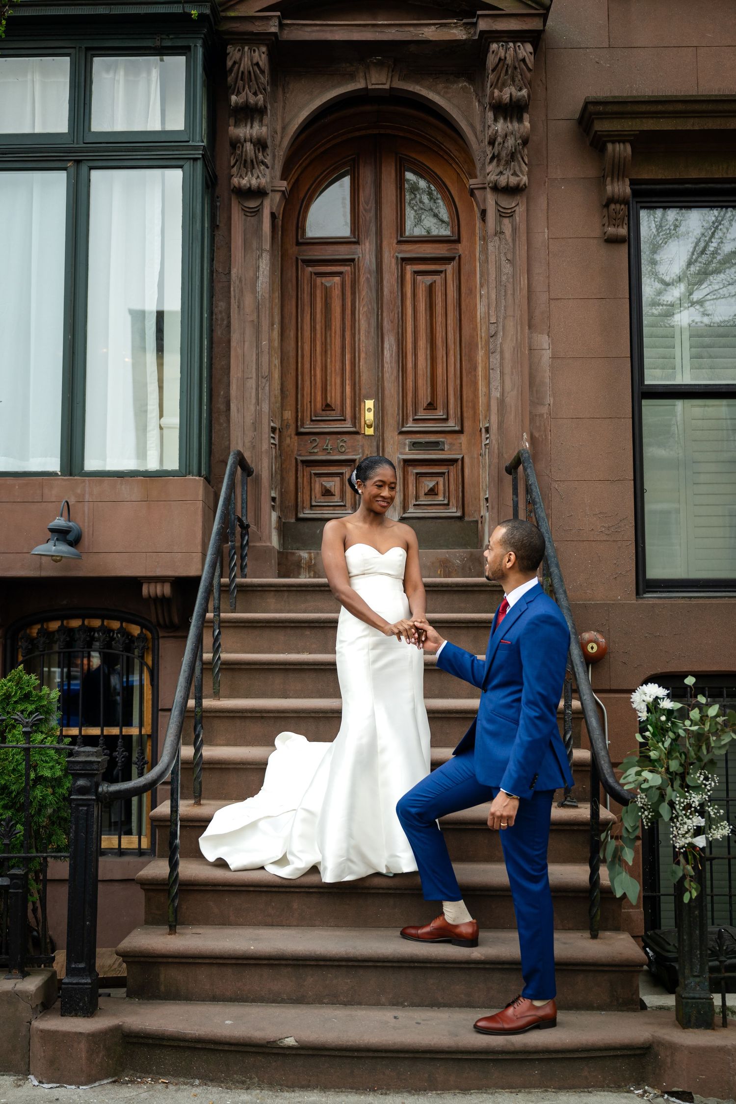 Romantic wedding proposal scene on historic brownstone steps.