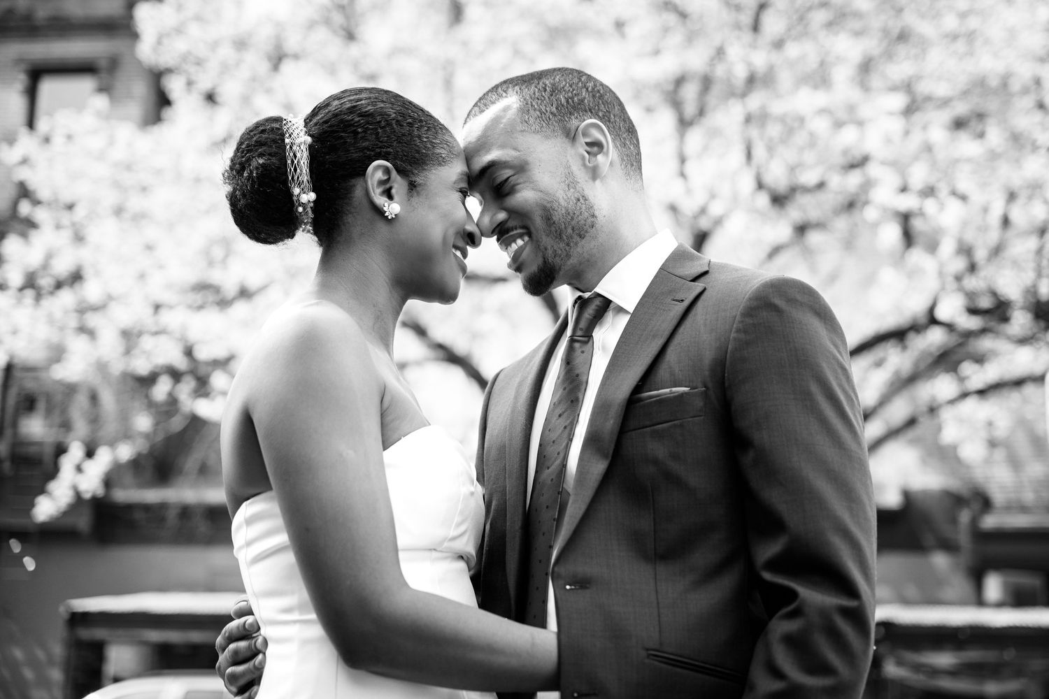 A tender moment between a couple in wedding attire sharing an intimate embrace outdoors.