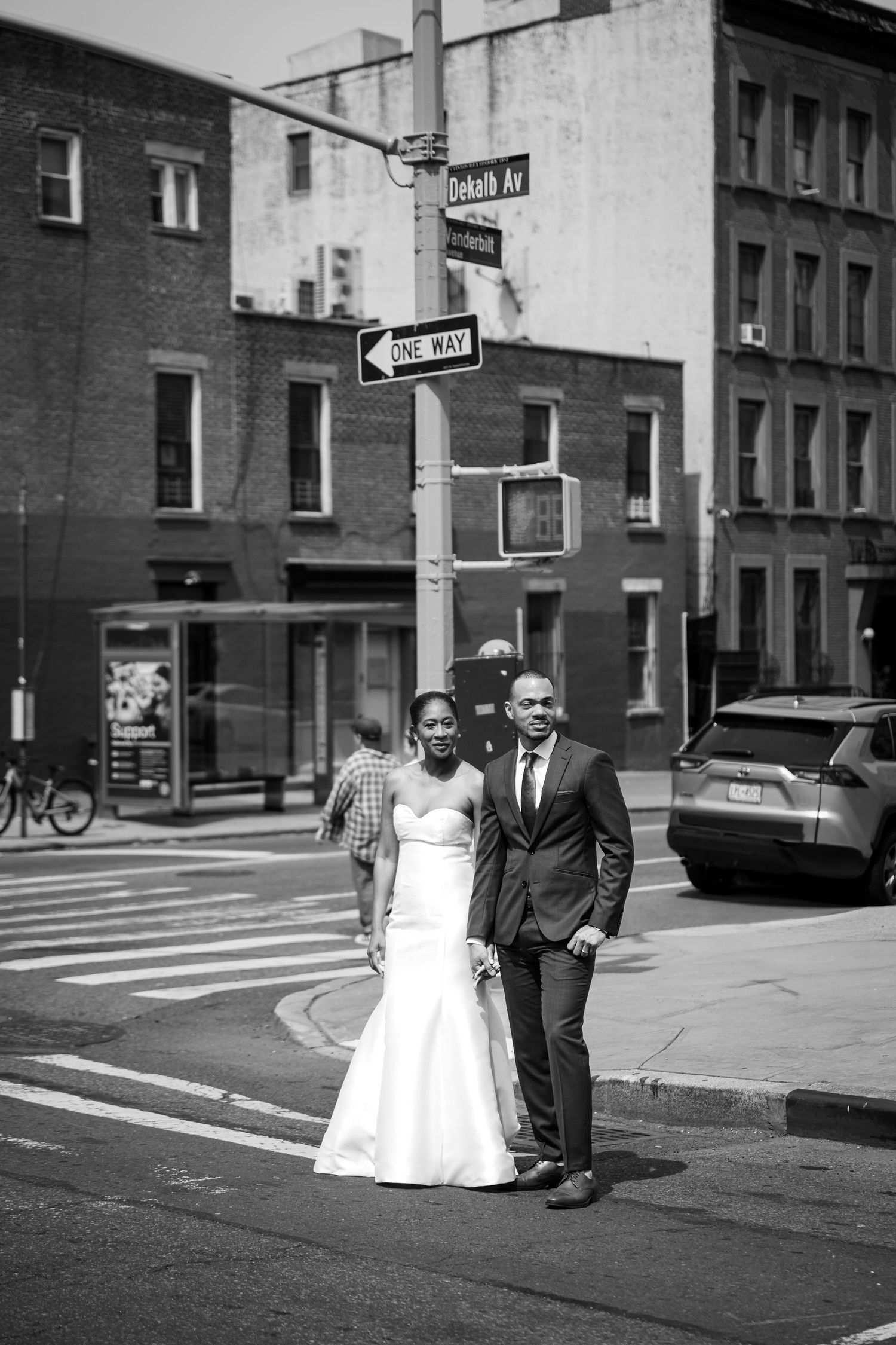 Black and white wedding portrait at city street intersection.
