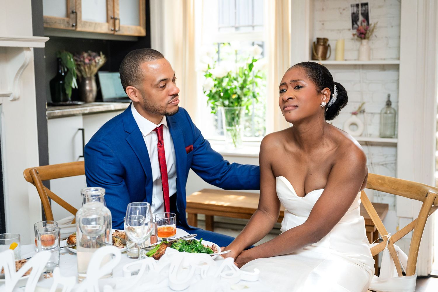 A couple shares an intimate moment at their wedding reception table.