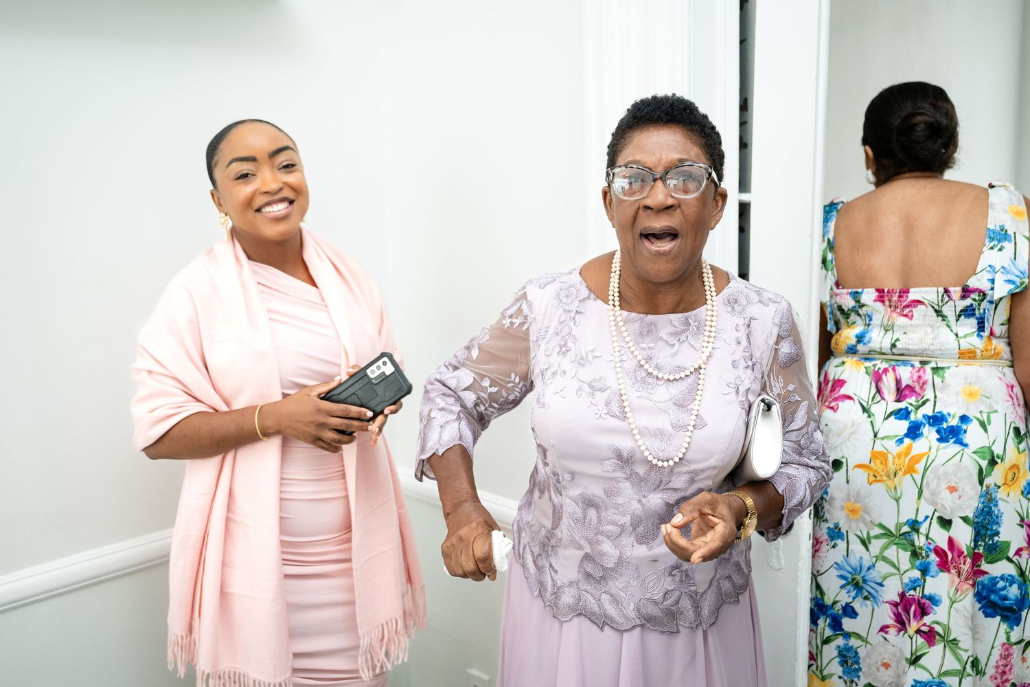 Wedding guests in pastel dresses sharing joyful moments at a celebration.