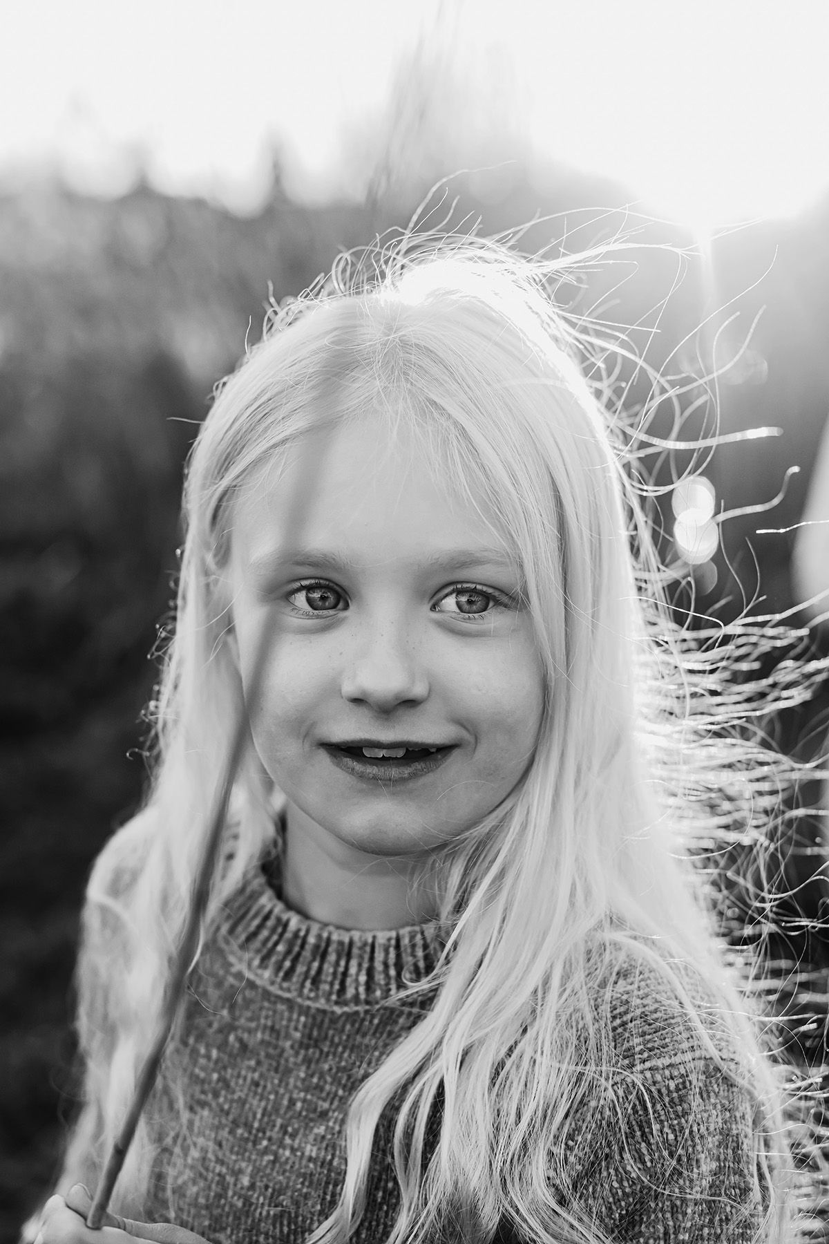 Levande uttrycksfullt porträtt av en ung flicka med blondt hår som blåser i vinden, fotograf Josefin Landhagen i Finspång.