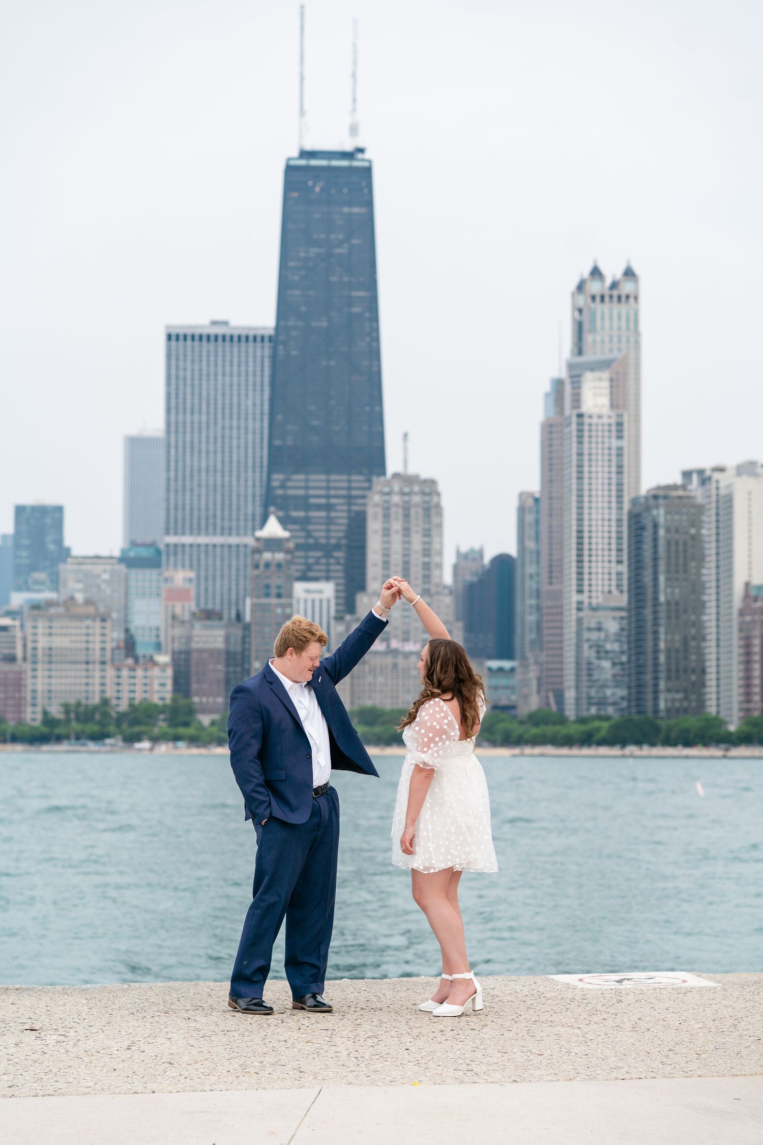 A romantic moment on North Avenue Beach with Chicago's iconic skyline across Lake Michigan in the background.